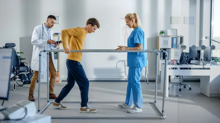hospital-physical-therapy-strong-patient-with-injury-making-first-steps-walks-holding-parallel-bars-physiotherapist-